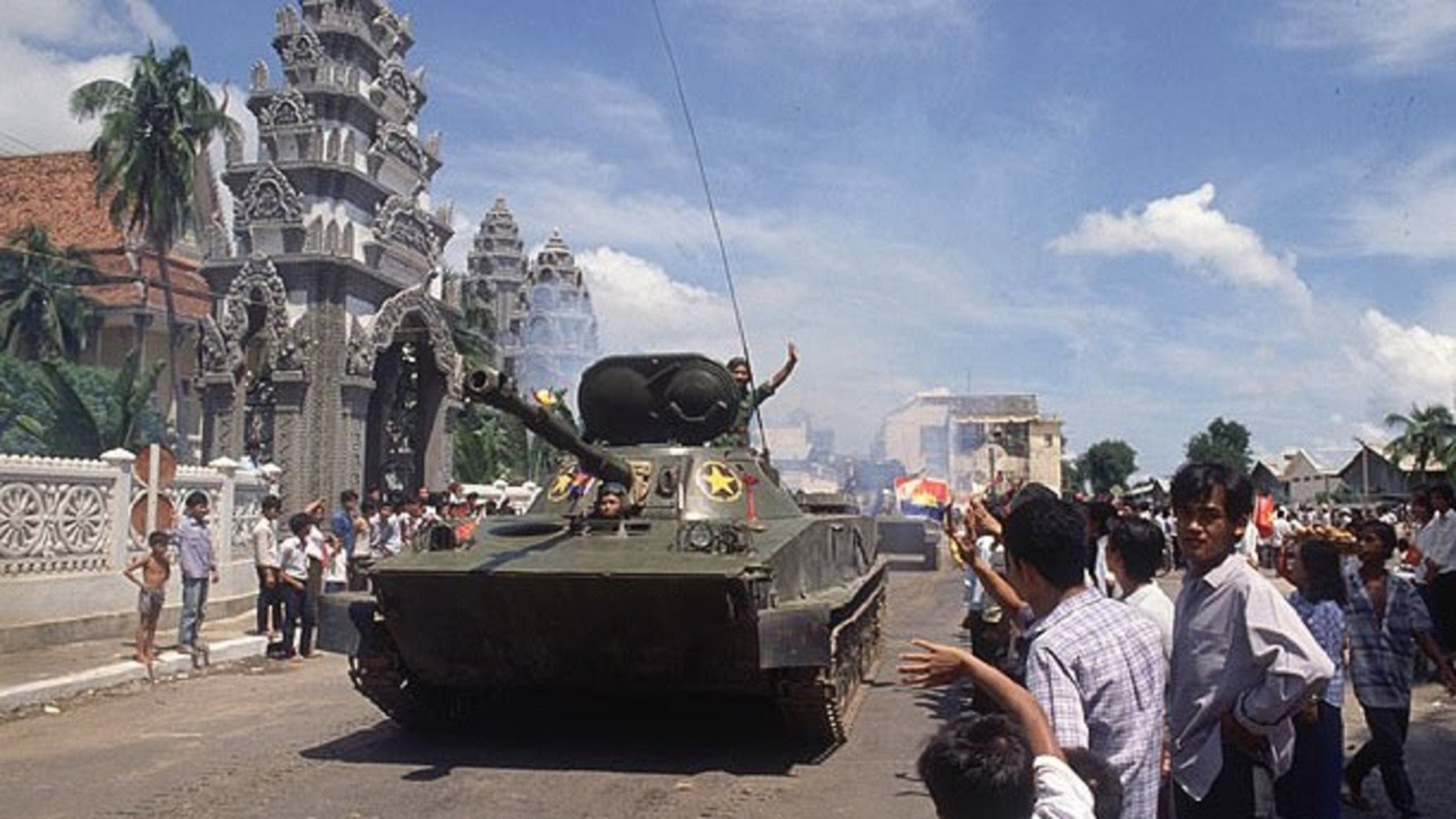 Các chiến sĩ xe tăng Việt Nam vẫy tay chào người dân Campuchia đứng hai bên đường trước khi rút quân về nước năm 1989.