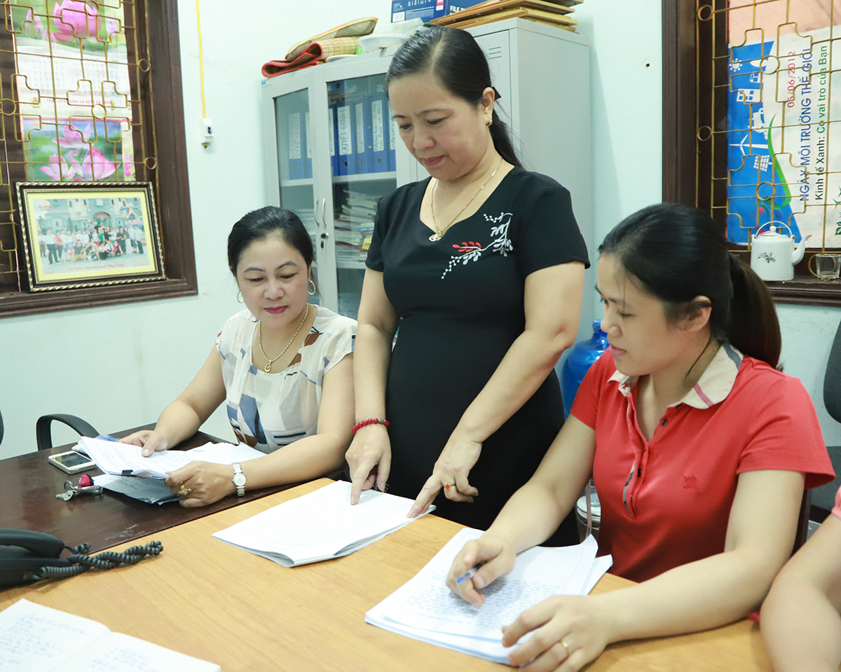 Đồng chí Thái Thị Hải Châu - Trưởng ban Dân vận đồng thời là Chủ tịch Ủy ban MTTQ huyện Hưng Nguyên (đứng) trao đổi với cán bộ Ủy ban MTTQ huyện. 