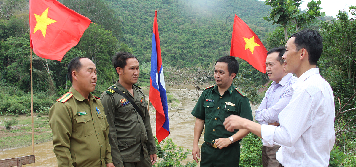 Cán bộ Đồn BP Mỹ Lý trao đổi với người dân bản biên giới Phà Chiếng và cán bộ công an biên phòng nước bạn Lào về tuần tra bảo vệ cột mốc đường biên.