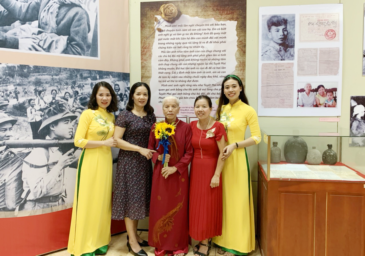 Bà Lê Thị Minh (đứng ở giữa) cùng con gái Tuyết Mai (thứ hai bên phải sang) và con dâu tại cuộc triển lãm Ký ức thời hoa lửa.