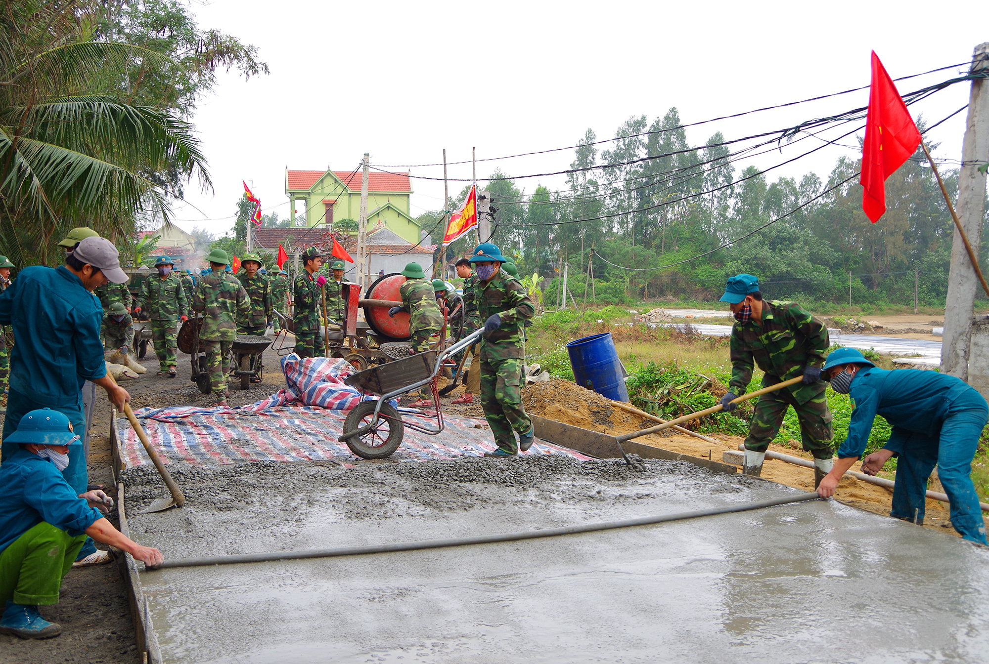 Cán bộ, chiến sĩ Bộ CHQS tỉnh giúp nhân dân xã An Hoà, huyện Quỳnh Lưu làm đường bê tông.