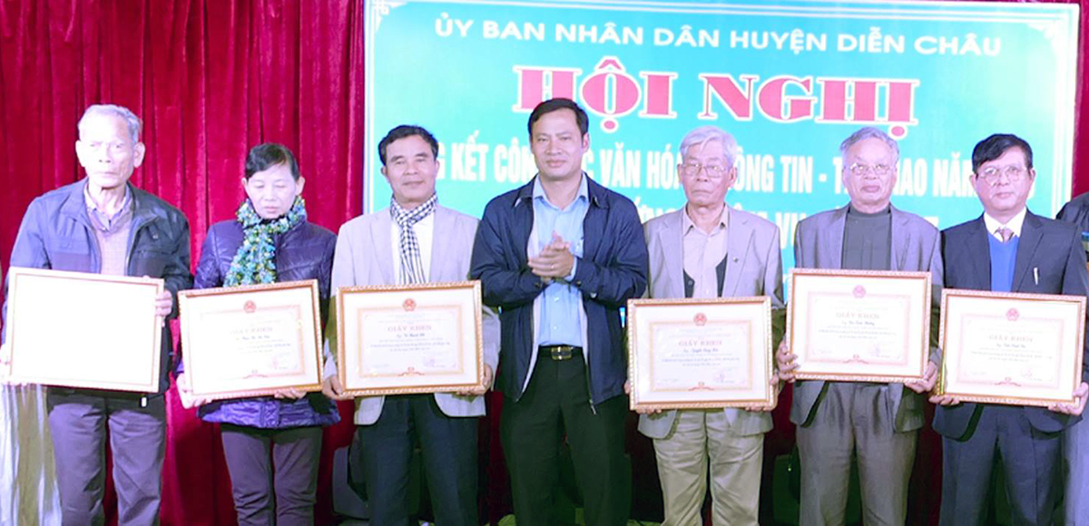 Thầy Đặng Quang Liễn (trái ảnh) nhận giấy khen của UBND huyện Diễn Châu về công tác văn hóa thông tin năm 2018