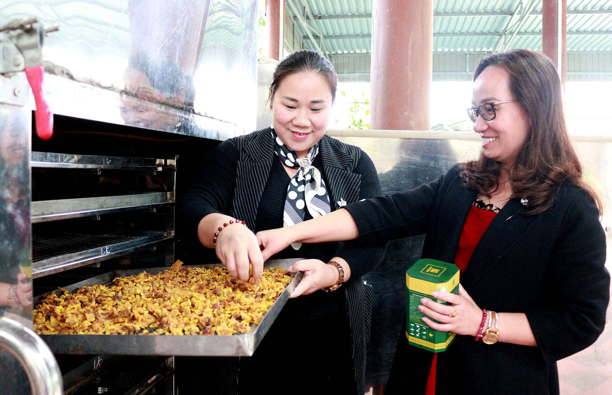 Lãnh đạo huyện Quế Phong (bên phải) khảo sát mô hình sấy chè hoa vàng của một hộ dân ở thị trấn Kim Sơn. Ảnh: Đ.C