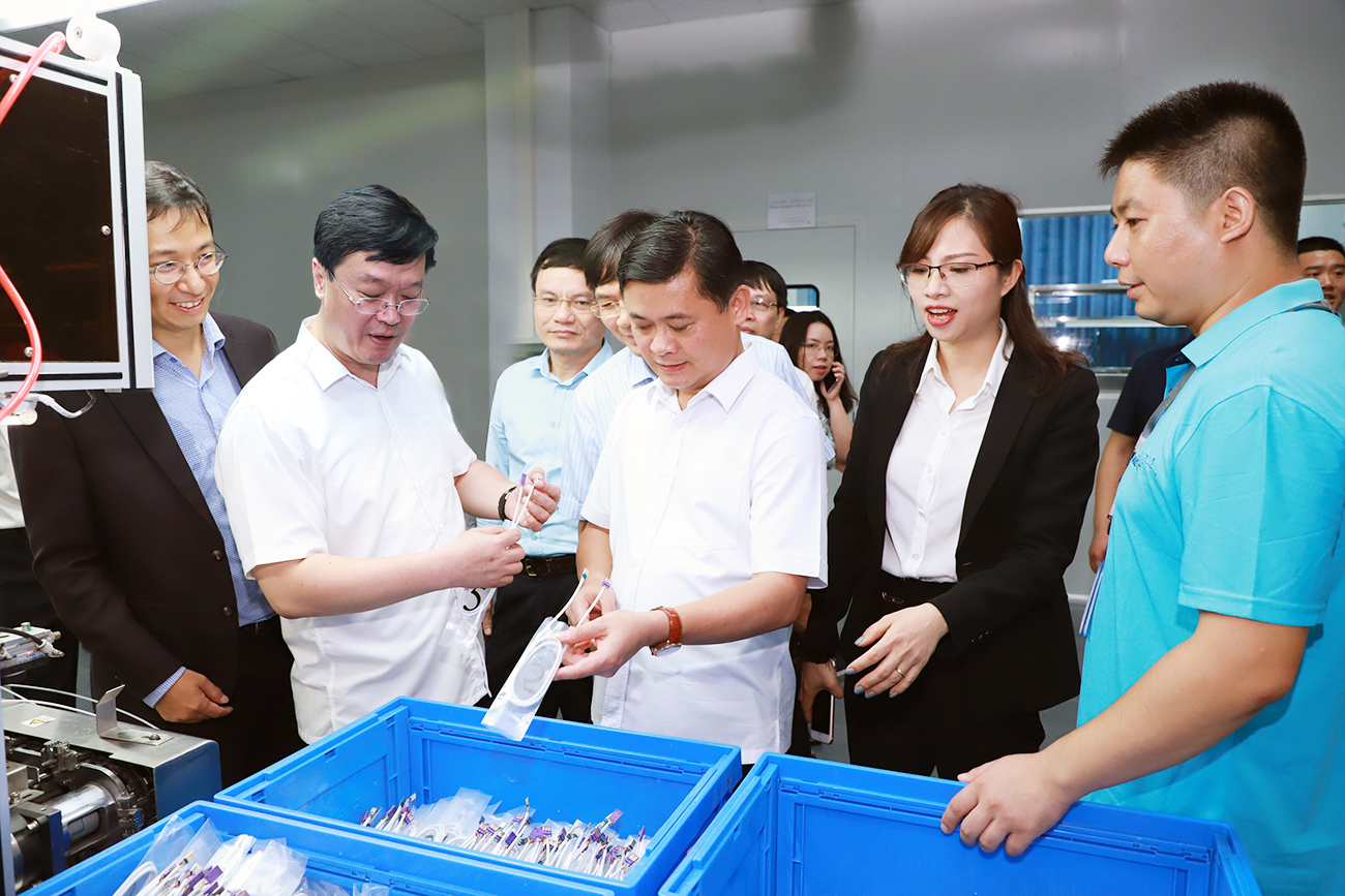 Bí thư Tỉnh ủy Thái Thanh Quý và Chủ tịch UBND tỉnh Nguyễn Đức Trung thăm dây chuyền sản xuất linh kiện điện tử tại nhà máy của Công ty LuxShare ICT đầu tư. 