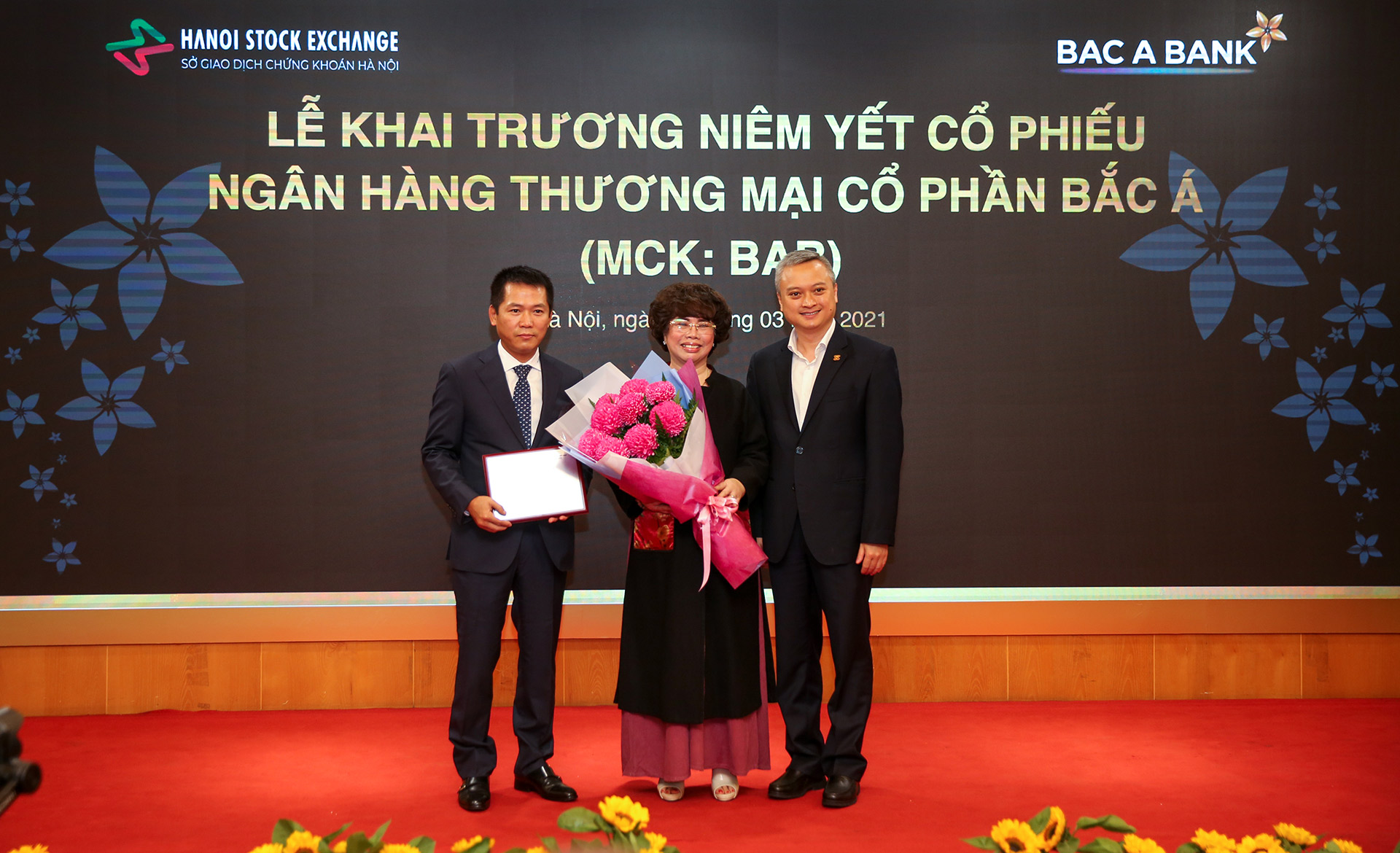 Đại diện BAC A BANK nhận bảng chứng nhận niêm yết cổ phiếu và hoa chúc mừng từ Sở GDCK Hà Nội.