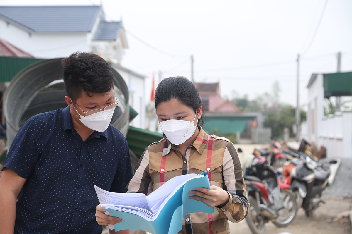 Cán bộ Ban GPMB huyện Hưng Nguyên kiểm tra sơ đồ quy hoạch tái định cư ở xóm Bùi Hạ, xã Hưng Trung.