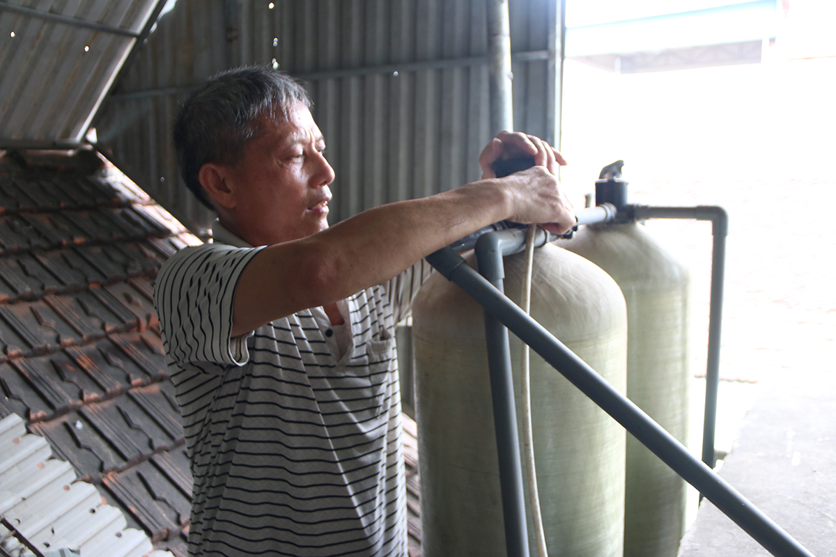 Ông Nguyễn Văn Năm - Xóm trưởng xóm Hải Nam, xã Diễn Bích (Diễn Châu) bên hệ thống lọc nước của gia đình.