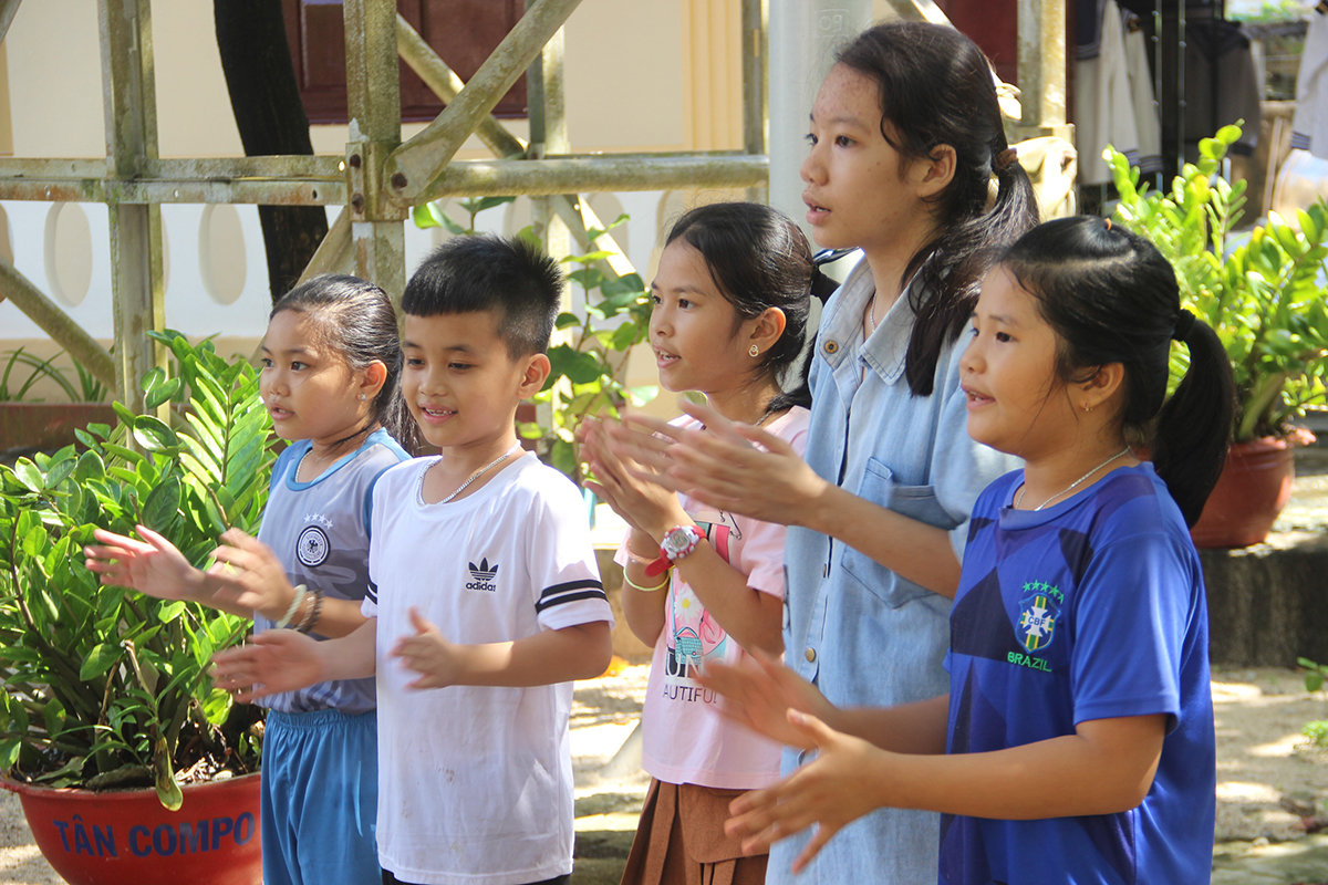 Những em nhỏ sống trên đảo Sinh Tồn vui tươi ca hát.