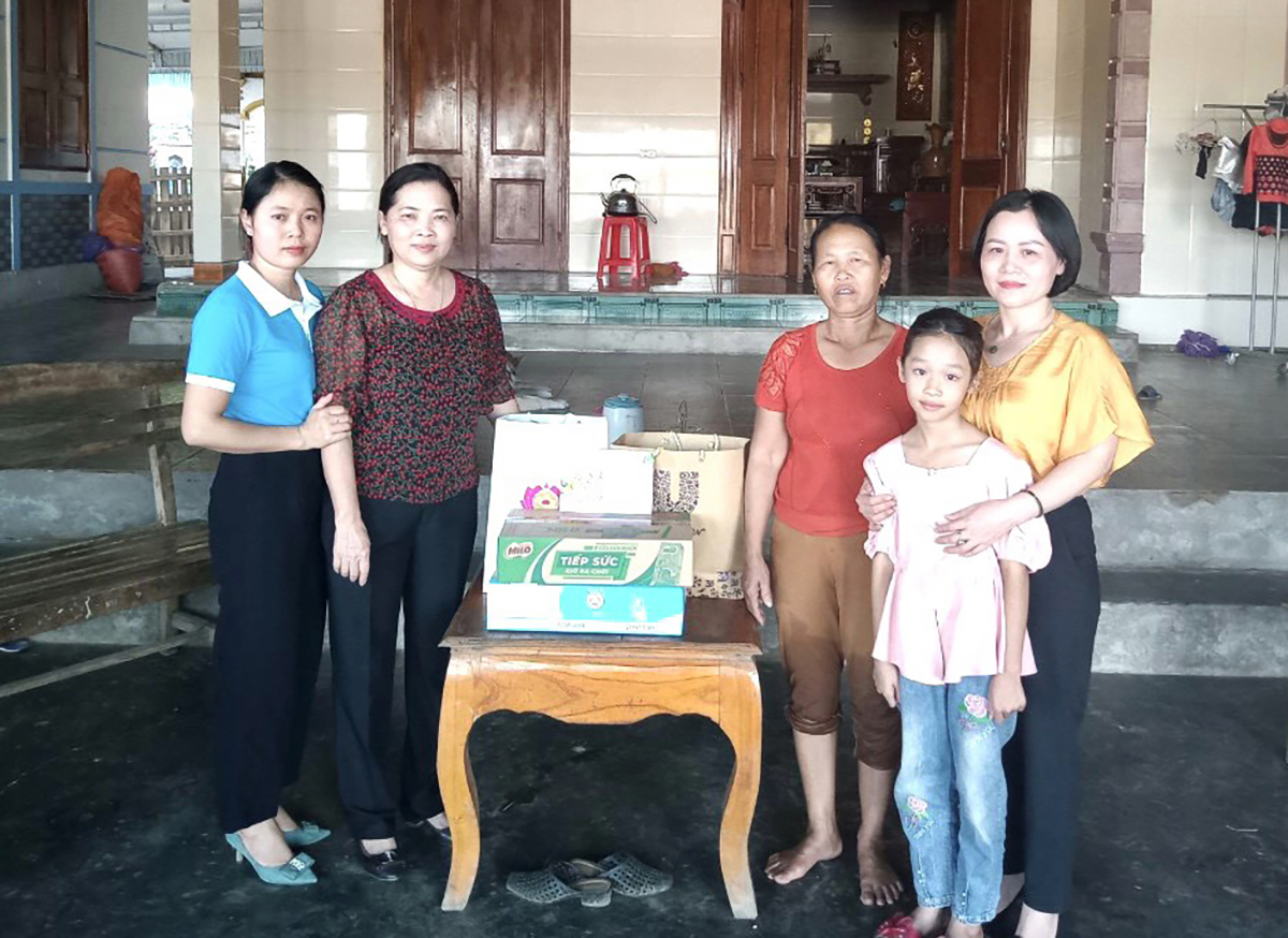 Chị Lê Thị Kim Chung (phải ảnh) tặng quà cho con nuôi là cháu Ngô Thị Ngọc Hân - xã Đại Đồng, huyện Thanh Chương. Ảnh: NVCC