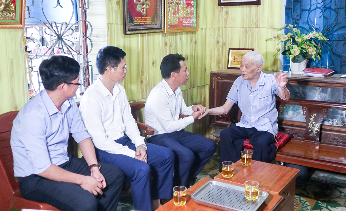 Cụ Hà Văn Tải trò chuyện cùng lãnh đạo xã Hưng Lộc.
