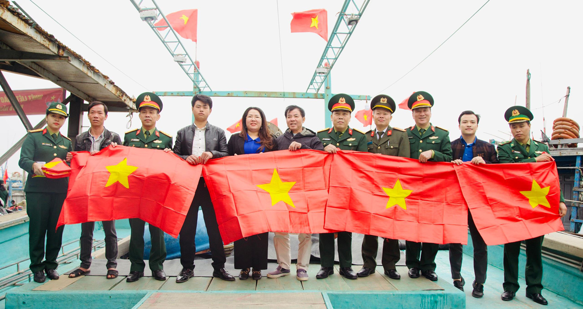 Đoàn Thanh niên các đơn vị trao tặng hơn 600 lá cờ Tổ quốc cho ngư dân vươn khơi bám biển tại cảng cá Quỳnh Phương (thị xã Hoàng Mai). Ảnh: CSCC