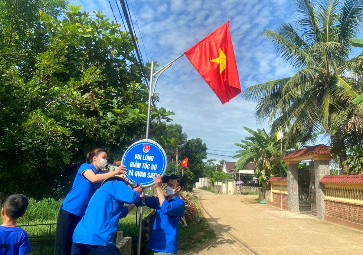 Đoàn thanh niên xã Nghĩa An (Nghĩa Đàn) chỉnh trang đường cờ, biển cảnh báo giao thông ở giáo xứ Đồng Tâm. Ảnh: Mai Phượng