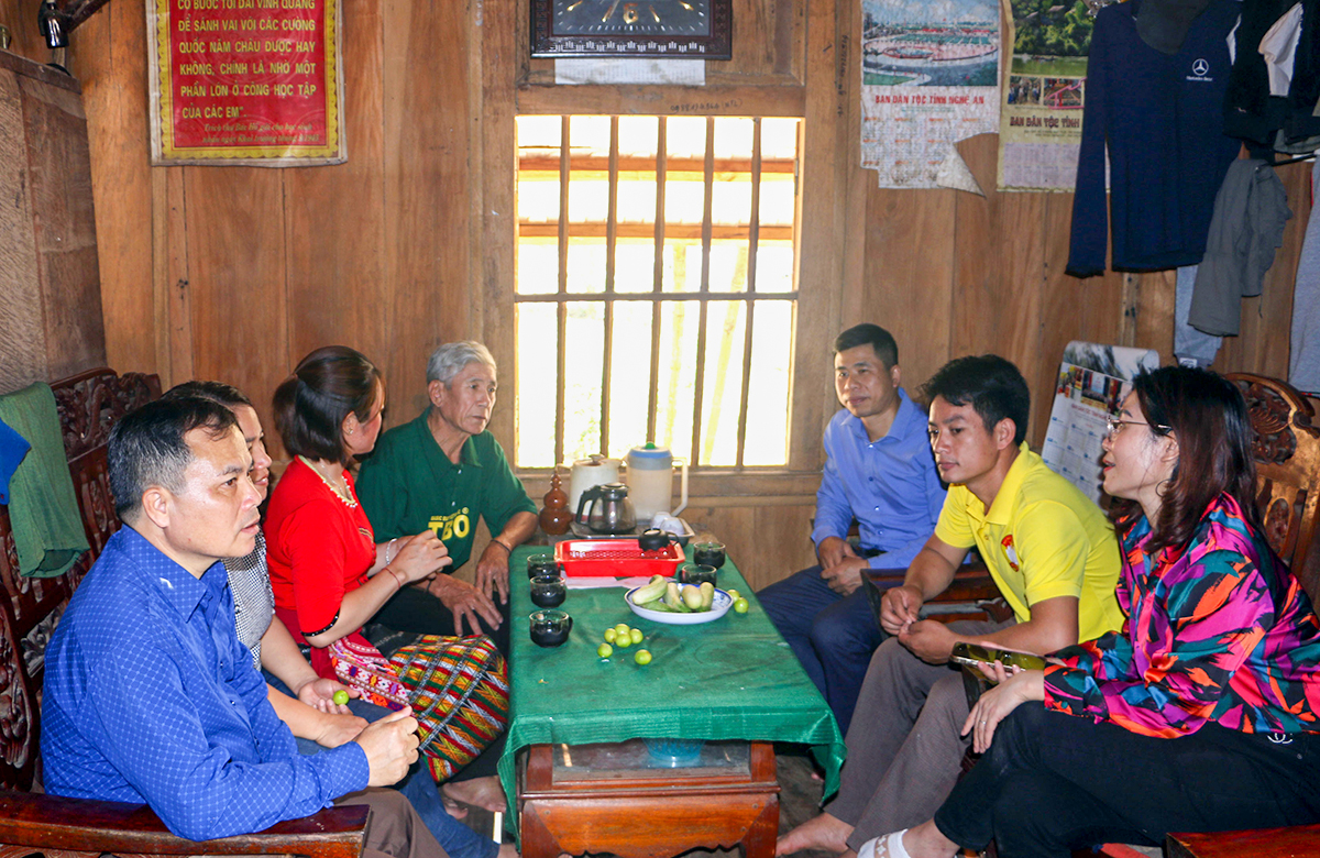 Trưởng bản Piêng Mựn Kha Thị Hoa (áo đỏ) và cán bộ xã Mai Sơn trò chuyện với ông Lô Minh Toán (thứ 4 trái sang) - người gương mẫu hiến đất có bìa đỏ để mở rộng đường vào khu sản xuất.