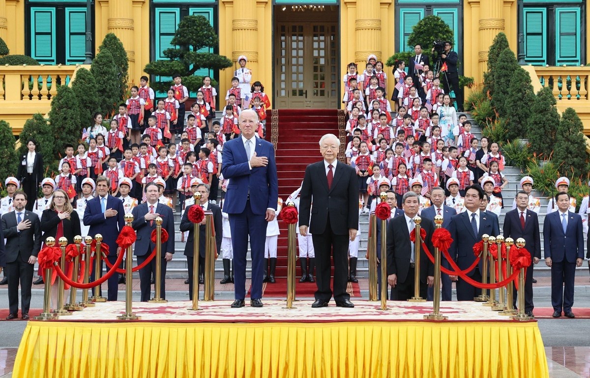 Tổng Bí thư Nguyễn Phú Trọng và Tổng thống Hoa Kỳ Joe Biden trên bục danh dự, thực hiện nghi thức chào cờ. Ảnh: TTXVN