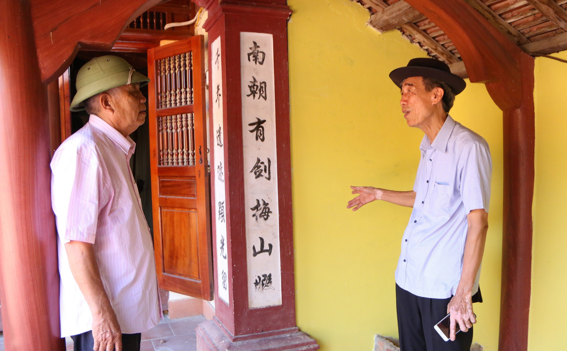 Nhà nghiên cứu văn hóa Thái Huy Bích (bên phải) giải thích đôi câu đối trong Đền Chiêu Trưng phía bờ Nam sông Lam.