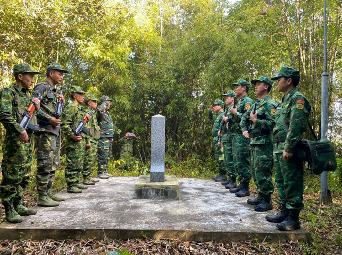Đội hình tuần tra Đồn Biên phòng Cửa khẩu quốc tế Nậm Cắn (Nghệ An, Việt Nam) cùng Đại đội 221 (Xiêng Khoảng, Lào) thực hiện nghi thức chào cột mốc biên giới. Ảnh: CSCC