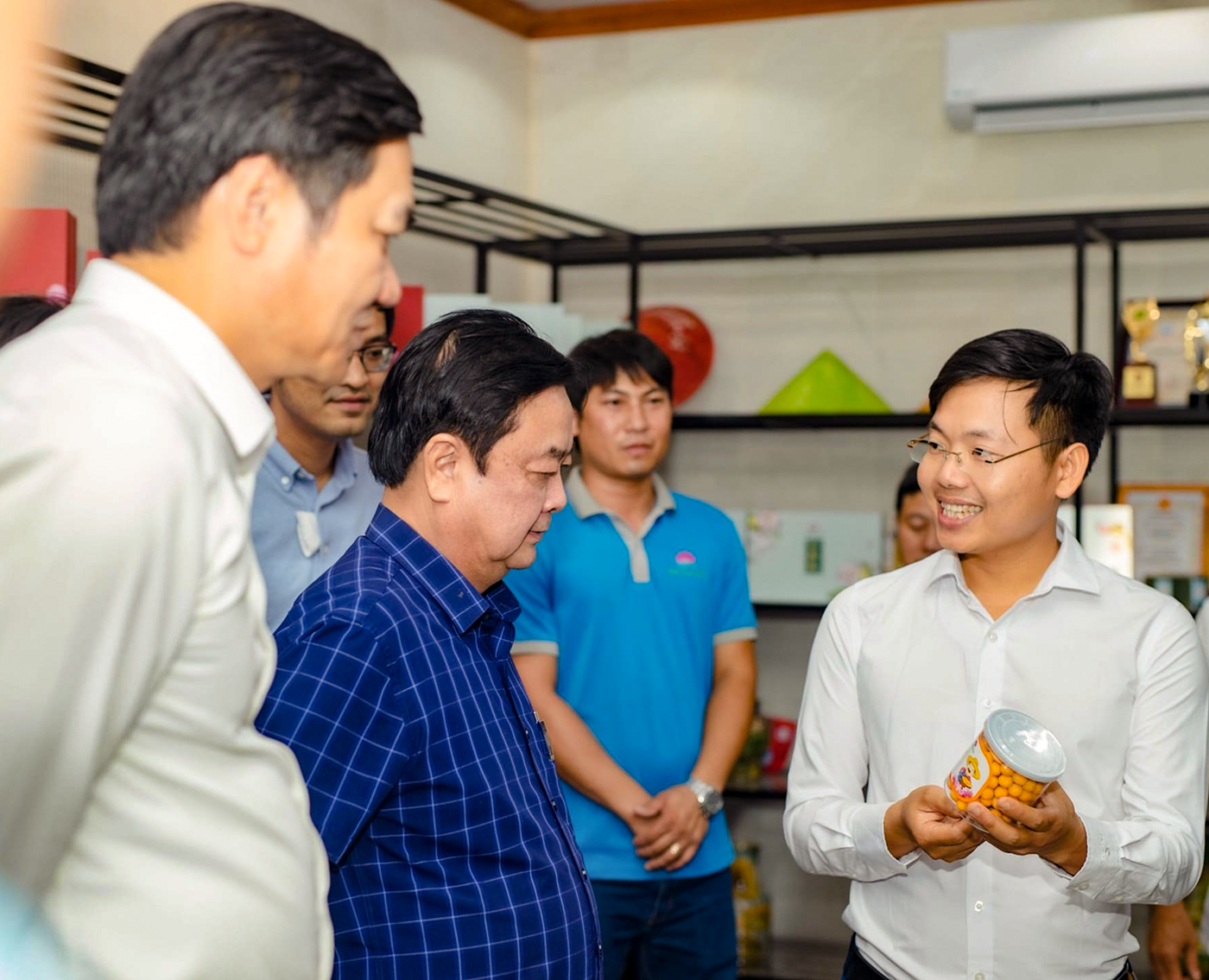 Phạm Kim Tiến giới thiệu sản phẩm HTX Sen Quê Bác với Bộ trưởng Bộ NN&PTNT và lãnh đạo tỉnh. Ảnh: Thanh Phúc