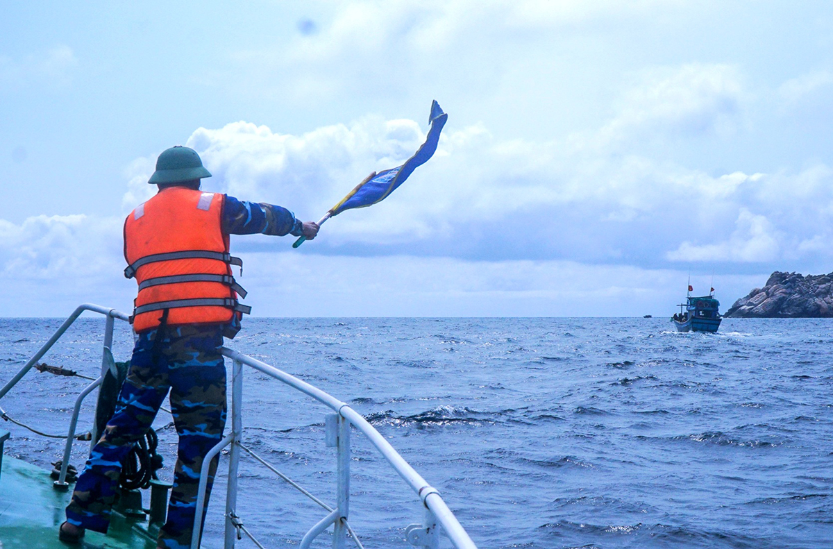 Thuyền phó Nguyễn Hữu Hảo dùng cờ hiệu kiểm ngư yêu cầu tàu cá có dấu hiệu vi phạm dừng hoạt động, chấp hành yêu cầu kiểm tra của Đoàn công tác liên ngành.